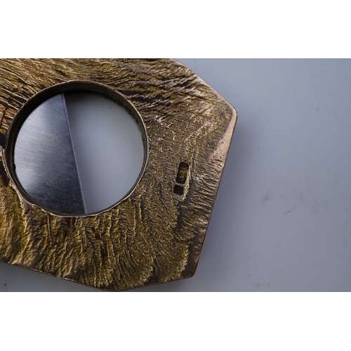 347 - Dunhill, a 9ct gold and steel cigar cutter, circa 1968, with a samorodok-style finish enclosing a sl... 