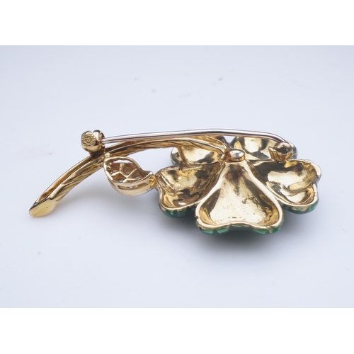 359 - An enamel and diamond brooch, designed as a flower, its petals applied with green enamel in a grid p... 