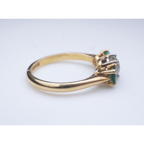 360 - An emerald and diamond three-stone ring, claw-set with a circular-cut diamond weighing approximately... 