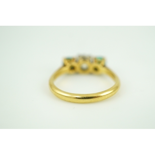 360 - An emerald and diamond three-stone ring, claw-set with a circular-cut diamond weighing approximately... 