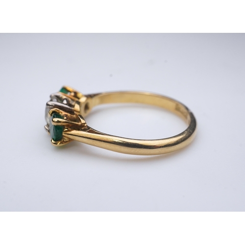 360 - An emerald and diamond three-stone ring, claw-set with a circular-cut diamond weighing approximately... 