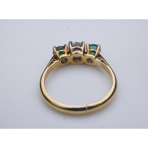 360 - An emerald and diamond three-stone ring, claw-set with a circular-cut diamond weighing approximately... 