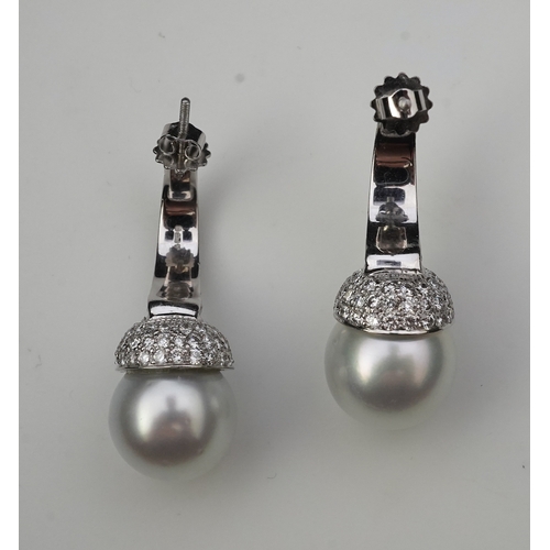 381 - A pair of South Sea cultured pearl and diamond earrings each designed as a half hoop, pavé-set with ... 