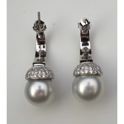 381 - A pair of South Sea cultured pearl and diamond earrings each designed as a half hoop, pavé-set with ... 