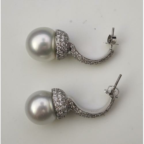 381 - A pair of South Sea cultured pearl and diamond earrings each designed as a half hoop, pavé-set with ... 