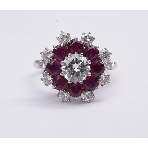 385 - A ruby and diamond ring of cluster design, set with a brilliant-cut diamond weighing approximately 0... 