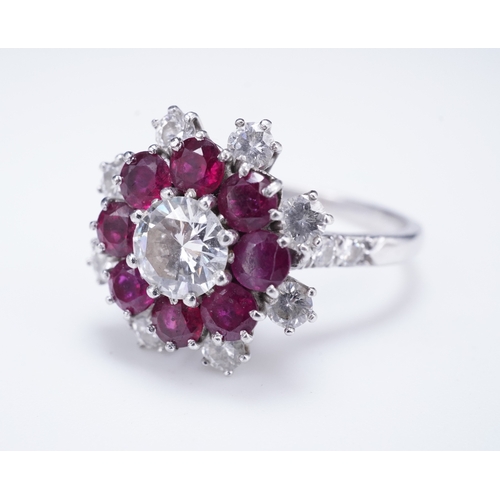 385 - A ruby and diamond ring of cluster design, set with a brilliant-cut diamond weighing approximately 0... 