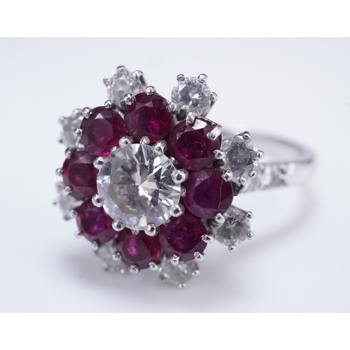 385 - A ruby and diamond ring of cluster design, set with a brilliant-cut diamond weighing approximately 0... 