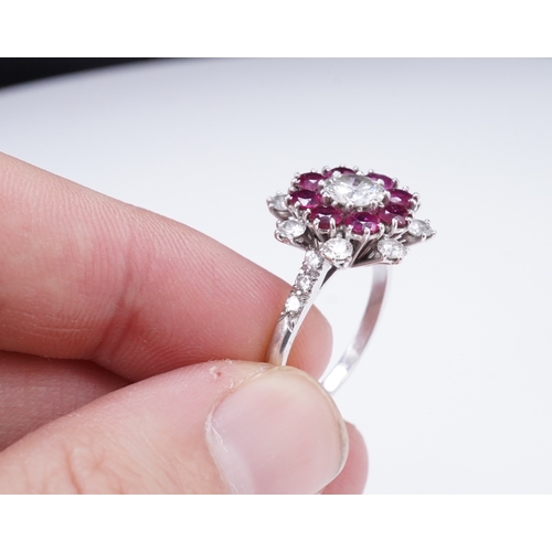 385 - A ruby and diamond ring of cluster design, set with a brilliant-cut diamond weighing approximately 0... 