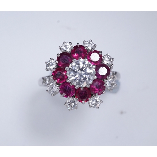 385 - A ruby and diamond ring of cluster design, set with a brilliant-cut diamond weighing approximately 0... 