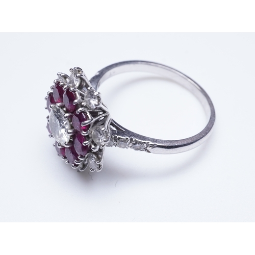 385 - A ruby and diamond ring of cluster design, set with a brilliant-cut diamond weighing approximately 0... 