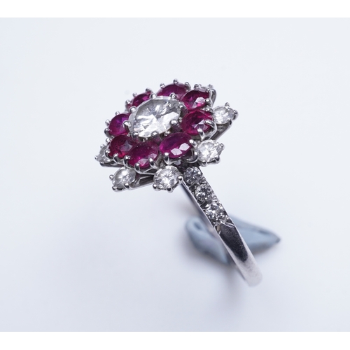 385 - A ruby and diamond ring of cluster design, set with a brilliant-cut diamond weighing approximately 0... 