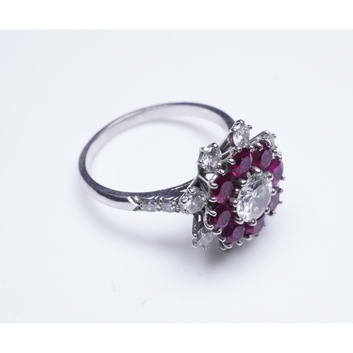 385 - A ruby and diamond ring of cluster design, set with a brilliant-cut diamond weighing approximately 0... 