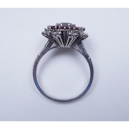 385 - A ruby and diamond ring of cluster design, set with a brilliant-cut diamond weighing approximately 0... 