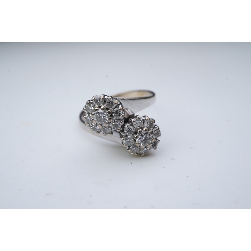 387 - A diamond 'toi et moi' ring, circa 1980 of crossover design, composed of two clusters of brilliant-c... 