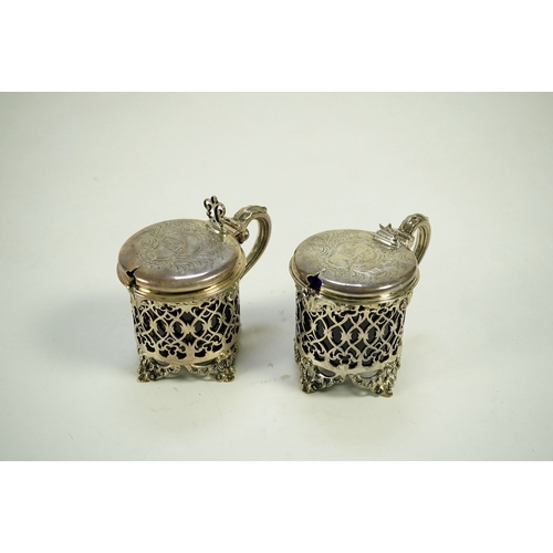 39 - A near pair of ornate Victorian pierced silver drum shaped mustard pots and covers, one by Charles T... 