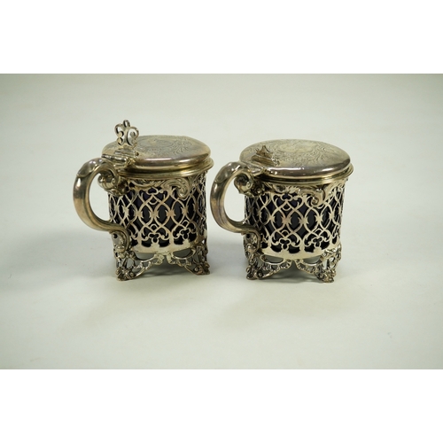 39 - A near pair of ornate Victorian pierced silver drum shaped mustard pots and covers, one by Charles T... 