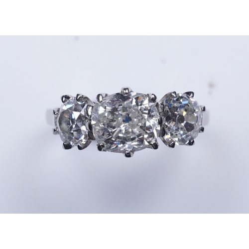 390 - A three-stone diamond ring, claw-set with three antique cushion-shaped diamonds totalling approximat... 