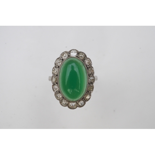 395 - A green chalcedony and diamond ring, early 20th century, of cluster design, set with an oval green c... 