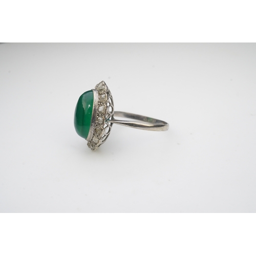 395 - A green chalcedony and diamond ring, early 20th century, of cluster design, set with an oval green c... 