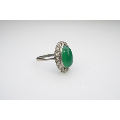 395 - A green chalcedony and diamond ring, early 20th century, of cluster design, set with an oval green c... 