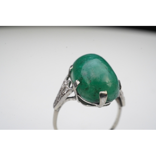 397 - An emerald and diamond ring, early 20th century, claw-set with a cabochon emerald, to shoulders mill... 