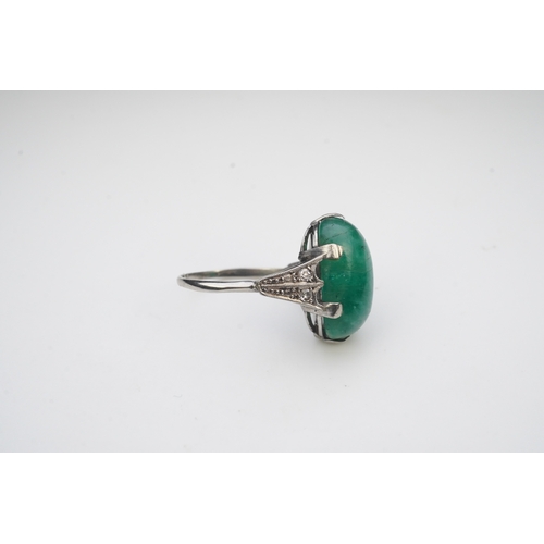 397 - An emerald and diamond ring, early 20th century, claw-set with a cabochon emerald, to shoulders mill... 