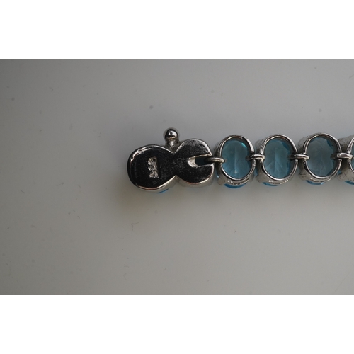 398 - A blue topaz bracelet, designed as an articulated line of oval blue topazes, mounted in silver, leng... 