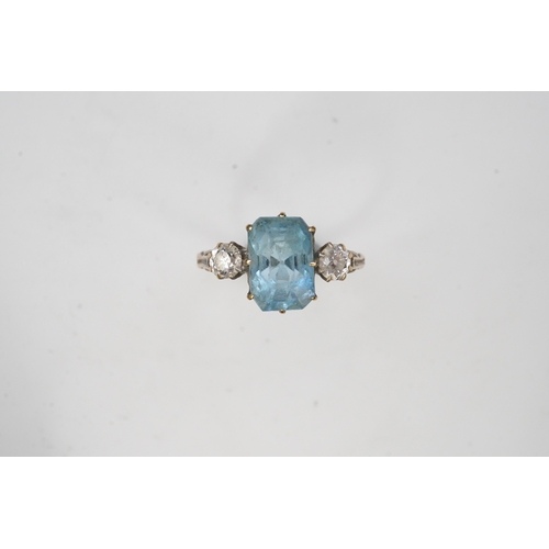 399 - An aquamarine and diamond ring, early 20th century, claw-set with a cushion-shaped aquamarine betwee... 