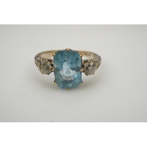 399 - An aquamarine and diamond ring, early 20th century, claw-set with a cushion-shaped aquamarine betwee... 