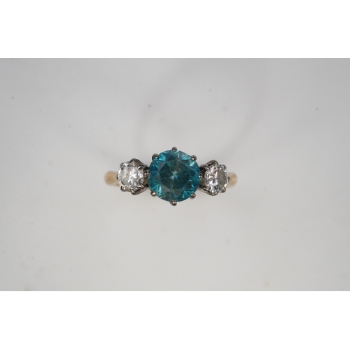 400 - A zircon and diamond ring, claw-set with a brilliant-cut blue zircon, between shoulders set with bri... 