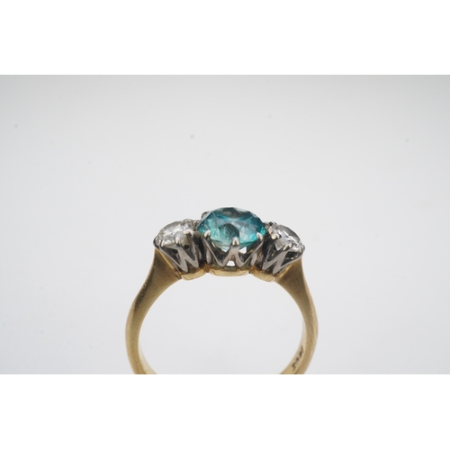 400 - A zircon and diamond ring, claw-set with a brilliant-cut blue zircon, between shoulders set with bri... 