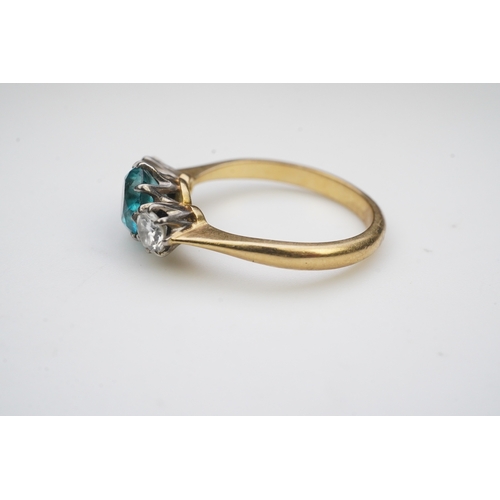 400 - A zircon and diamond ring, claw-set with a brilliant-cut blue zircon, between shoulders set with bri... 