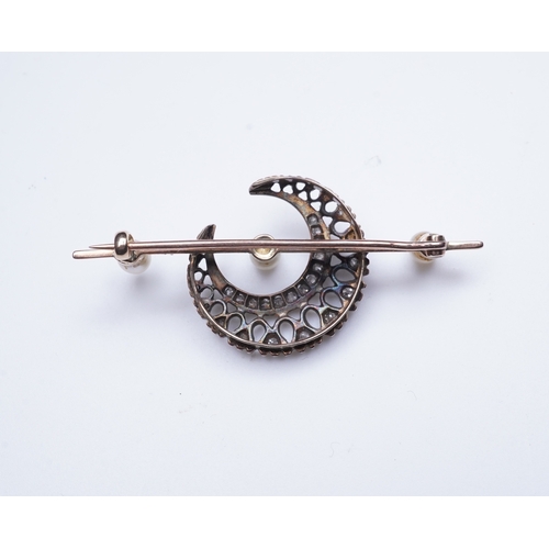 403 - An Edwardian pearl and diamond brooch, early 20th century, designed as a crescent moon set with cush... 