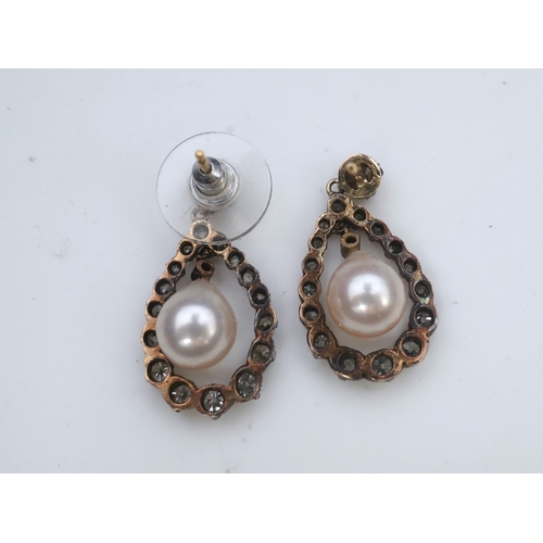 411 - A pair of cultured pearl and diamond earrings, each designed as a pear-shaped drop, suspending a cul... 