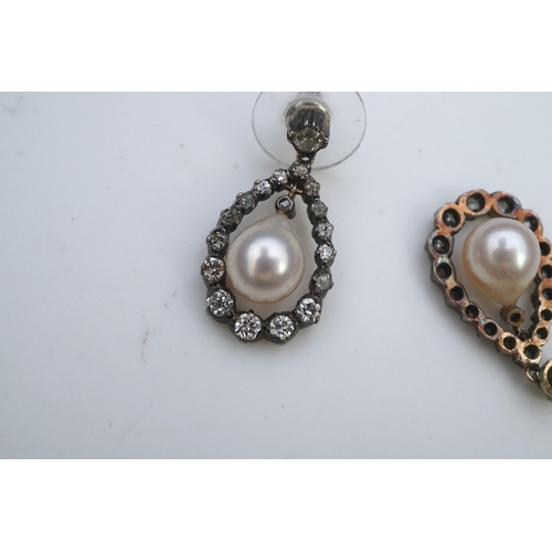 411 - A pair of cultured pearl and diamond earrings, each designed as a pear-shaped drop, suspending a cul... 