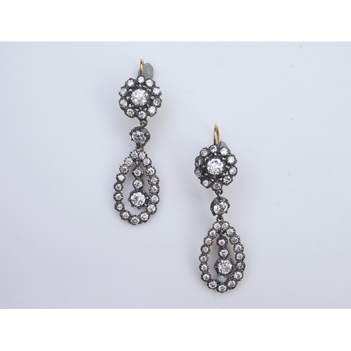 413 - A pair of diamond earrings, each of drop design, composed of a circular cluster suspending a pear-sh... 