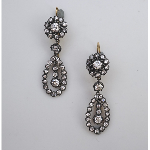 413 - A pair of diamond earrings, each of drop design, composed of a circular cluster suspending a pear-sh... 