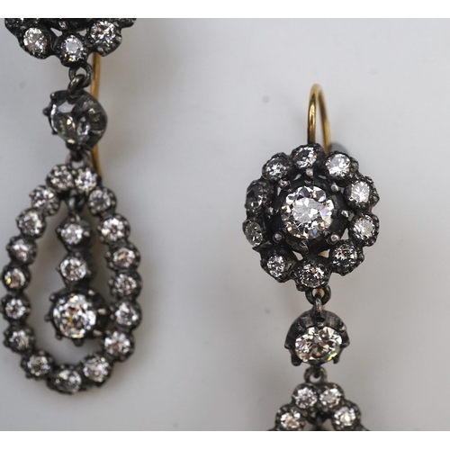 413 - A pair of diamond earrings, each of drop design, composed of a circular cluster suspending a pear-sh... 