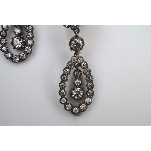 413 - A pair of diamond earrings, each of drop design, composed of a circular cluster suspending a pear-sh... 