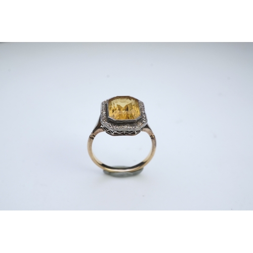 414 - A citrine and diamond ring, early 20th century, set with a step-cut citrine within a border of rose-... 