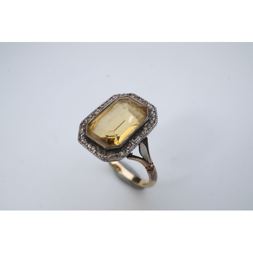 414 - A citrine and diamond ring, early 20th century, set with a step-cut citrine within a border of rose-... 