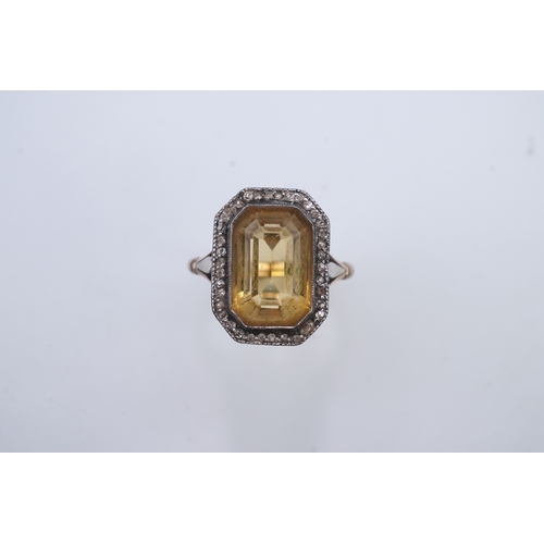 414 - A citrine and diamond ring, early 20th century, set with a step-cut citrine within a border of rose-... 