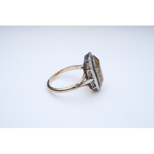 414 - A citrine and diamond ring, early 20th century, set with a step-cut citrine within a border of rose-... 