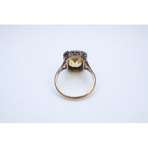 414 - A citrine and diamond ring, early 20th century, set with a step-cut citrine within a border of rose-... 