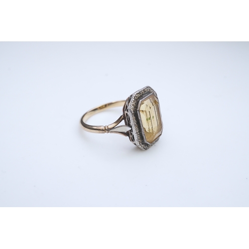 414 - A citrine and diamond ring, early 20th century, set with a step-cut citrine within a border of rose-... 