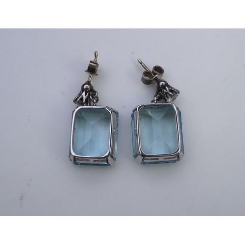 419 - A pair of aquamarine and diamond earrings, each set with a step-cut aquamarine, suspended from a bri... 