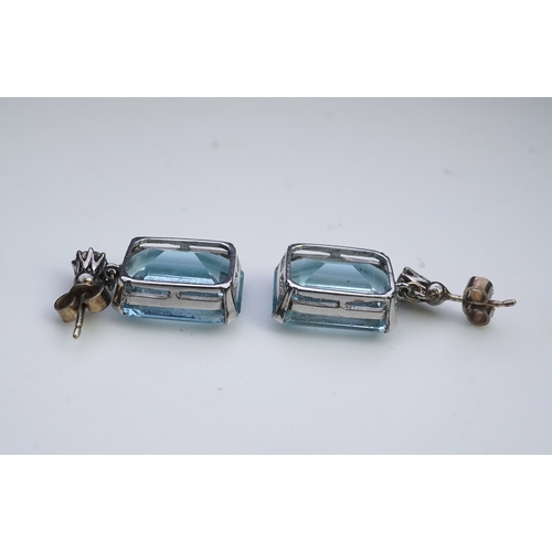 419 - A pair of aquamarine and diamond earrings, each set with a step-cut aquamarine, suspended from a bri... 