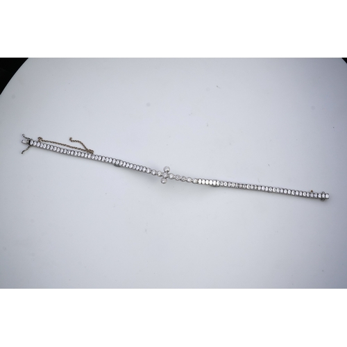 421 - A diamond bracelet, designed as a sequence of links set with step-cut diamonds, centring on a cross ... 