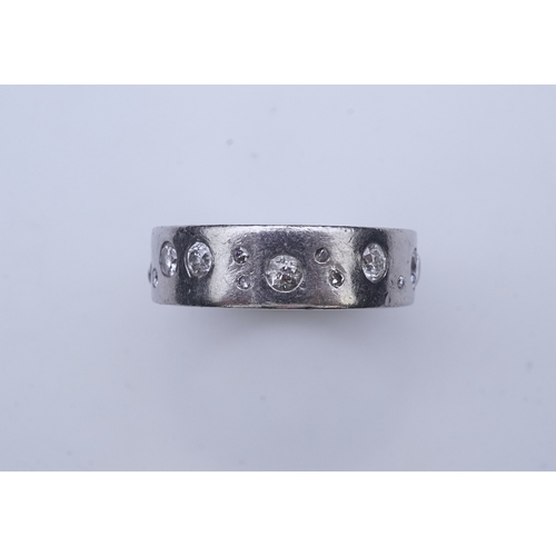 423 - A platinum and diamond eternity ring, set with a continuous band of scattered brilliant-cut diamonds... 